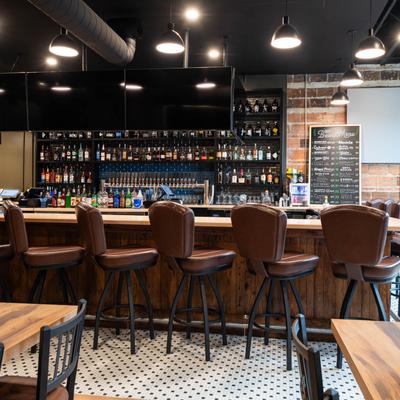 Brown leather barstools by the bar.