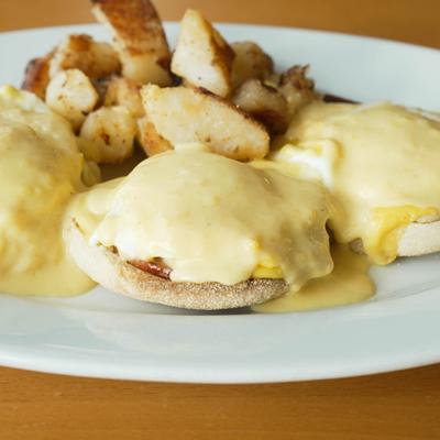 Eggs benedict served with home fries.