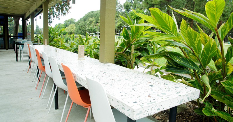 Exterior, outdoor tables and seats with greenery hedgerow