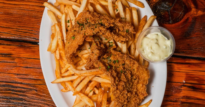 Fried catfish served over a bed of french fries