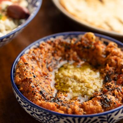 Muhammara served alongside a salad and pita bread.