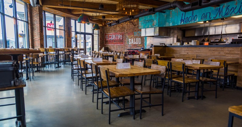 Interior, open space dining area, high and regular seating tables with chairs, concrete flooring