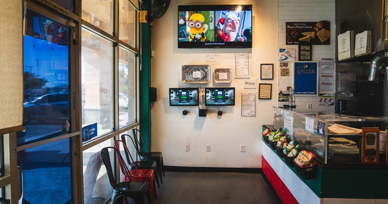 Food counter, chairs, tv on the wall above