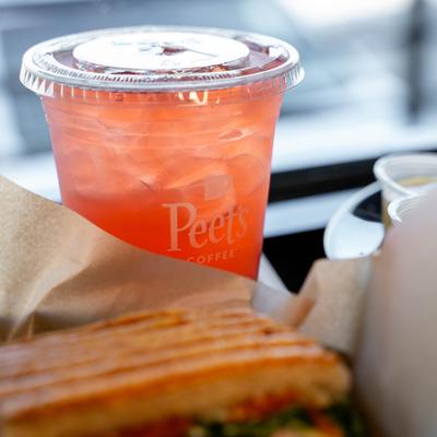 Iced red drink in a plastic cup on a table.
