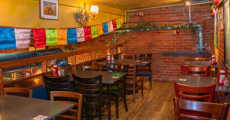 Interior, tables and chairs waiting for guests, brick walls with decorations