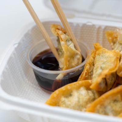 Fried Mandoo dumplings, with chopsticks dipping one into soy sauce.