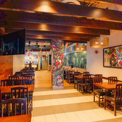 Dining room with colorful murals and wooden tables.