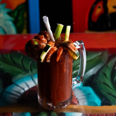 Heavily garnished Michelada cocktail served on the table.