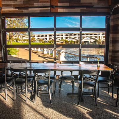 Dining area with a large window offering a clear view of a riverside scene.
