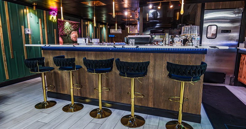 Bar with lined-up upholstered stools