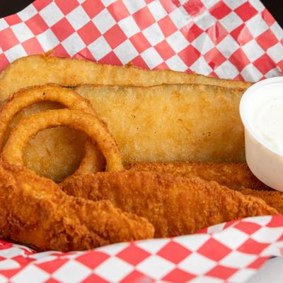 Chicken tenders, onion rings, and breaded zucchini with dipping sauce on checkered paper.