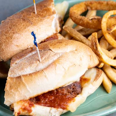 Meatball Sub served with fries and onion rings.