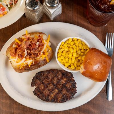 Hamburger steak, stuffed baked potato, and corn.