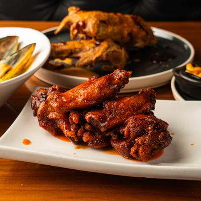 Plate of hot wings served on the table alongside other dishes.