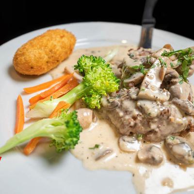 Stak with white mushroom gravy and veggies.