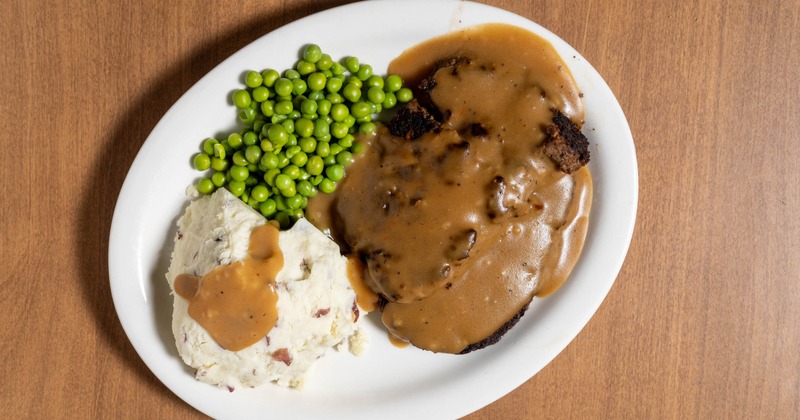Meatloaf with gravy, mashed potatoes, and peas