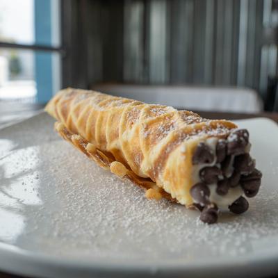 Single Cannoli served on a plate.