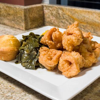 Fried shrimp served with collards, mac and cheese, and corn bread muffin.