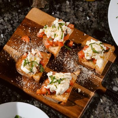 Bruschetta Romana served on a wooden board, top view.