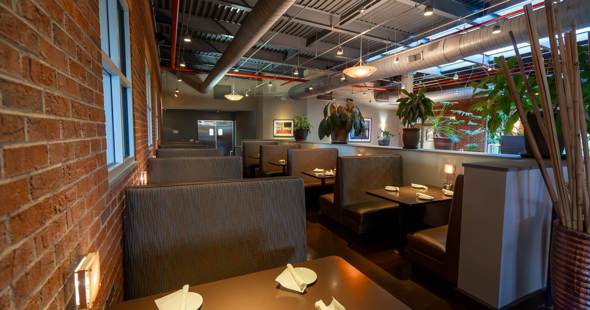 Interior, dining area, red brick wall, seating booths with tables, bamboo decoration