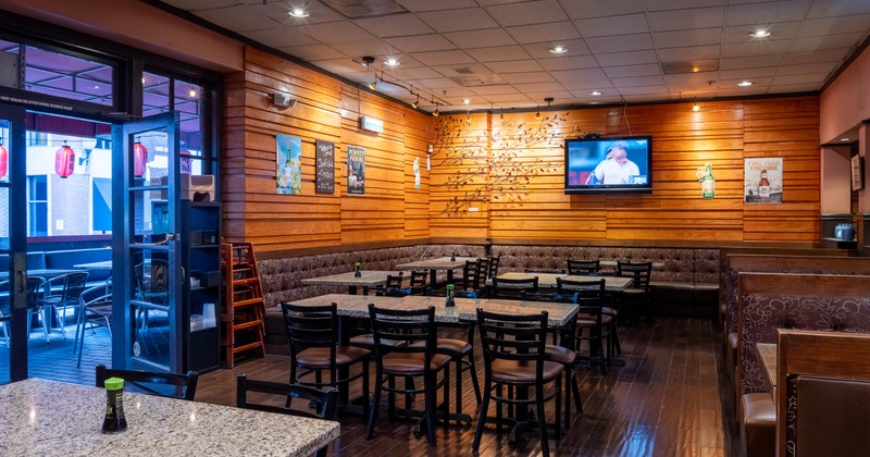 Modern restaurant interior with wooden walls, marble tables and dark furniture
