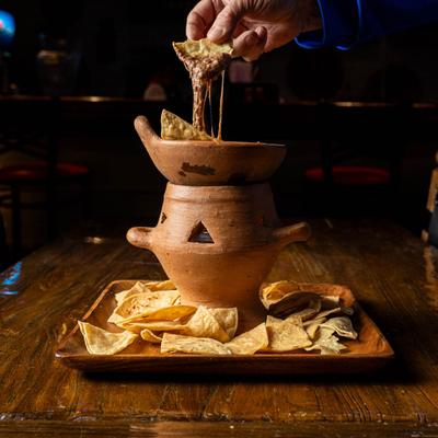 Chorizo, Bean, and Cheese Dip, served with corn chips on a table.