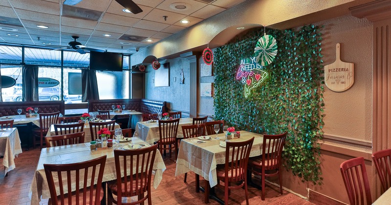 Interior, seating area, tables and chairs ready for guests, artificial plant decoration