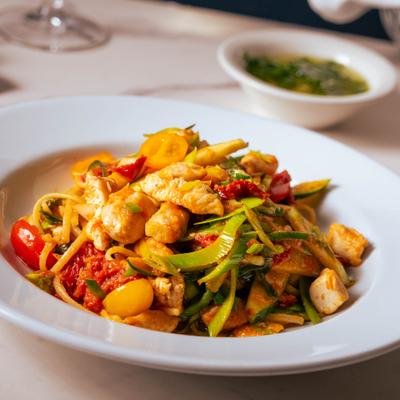 Linguine pasta with cherry tomatoes, leeks, and chicken pieces.