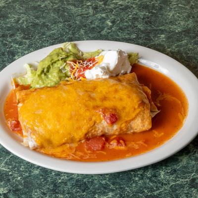 Burrito smothered in cheese sauce and savory tomato sauce, served with guacamole and sour cream.