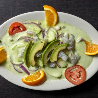 Aguachile Verde featuring raw shrimp marinated in citrus and green chiles with garnishes.