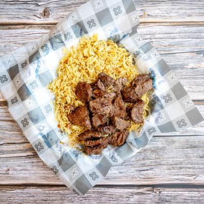 Steak Tips served on a bed of rice, top view.