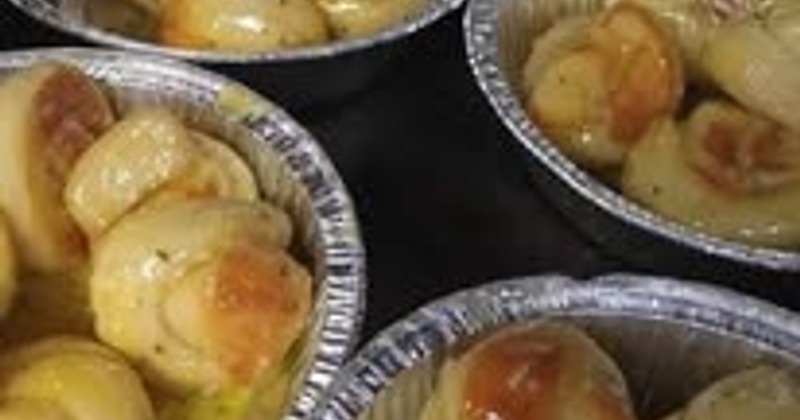 Several foil containers with garlic knots
