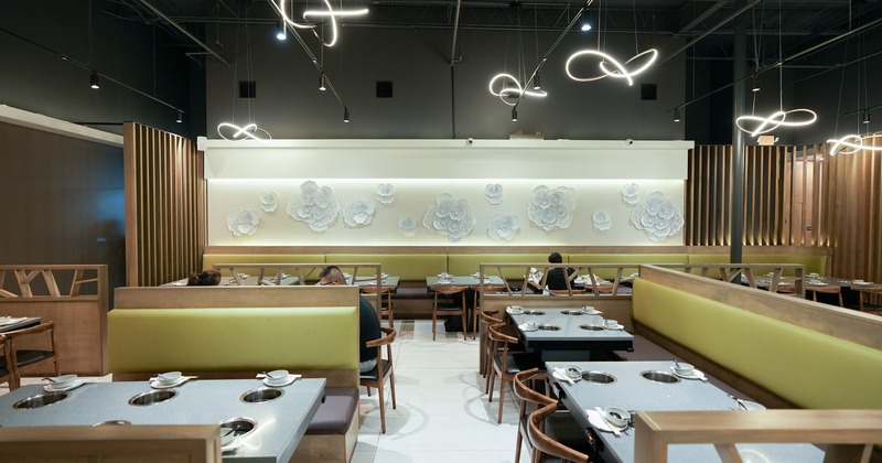 Spacious and modern dining area with tables equipped with built-in hot pot burners