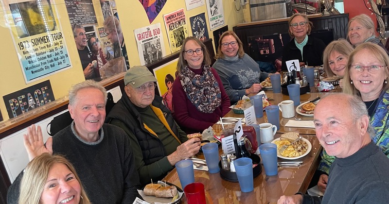 Cozy interior seating area with yellow painted walls covered with framed photos and music posters