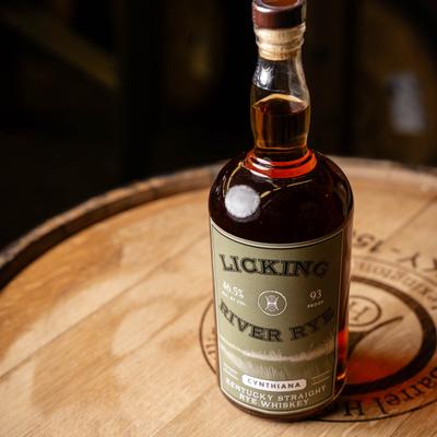 A bottle of Licking River Rye Whiskey on barrel top.