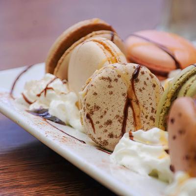 French macaroons served with cream, closeup
