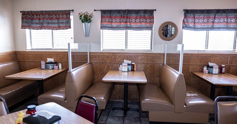 Cozy diner interior with empty tan booths and wooden tables