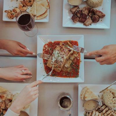 People serving themselves to food on the table, overhead view.