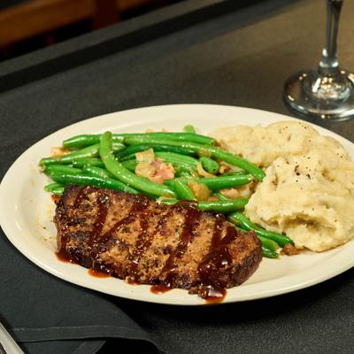 Meatloaf served with green beans and mashed potatoes.