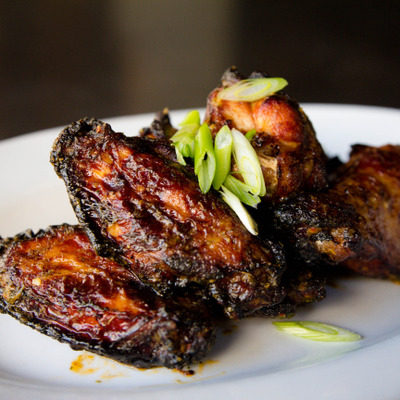 Blackened chicken wings, with scallions photo.