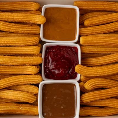 Traditional churros served with sweet dips.