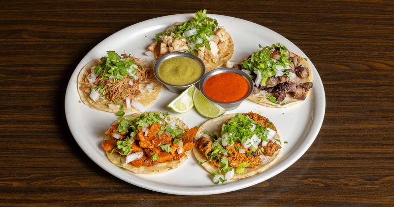 Tacos with assorted meats, onions, cilantro, lime, and red and green salsas
