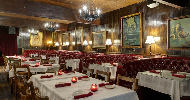A vintage-style interior - red leather booths, white tablecloths and chandeliers