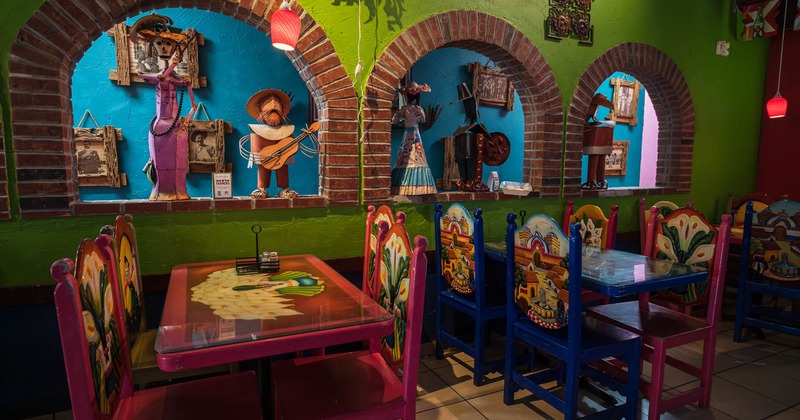 Inside, seating area with colorful tables and chairs