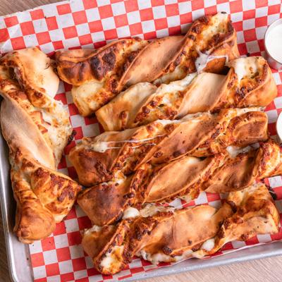 Cheese twists on red-and-white checkered paper.