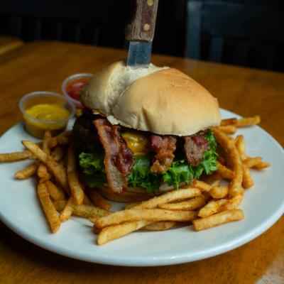 Bacon cheeseburger with fries and dipping sauces.