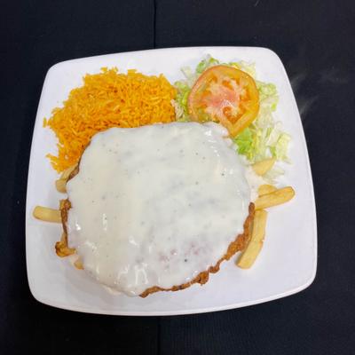 Chicken covered with white cheese with sides of rice and salad.