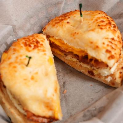 Bagel sandwich topped with melted cheese.