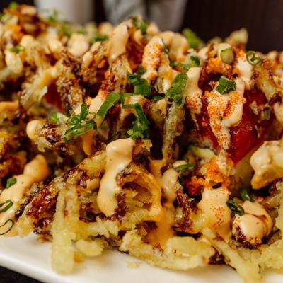 Crispy sushi roll topped with sauce and scallions.