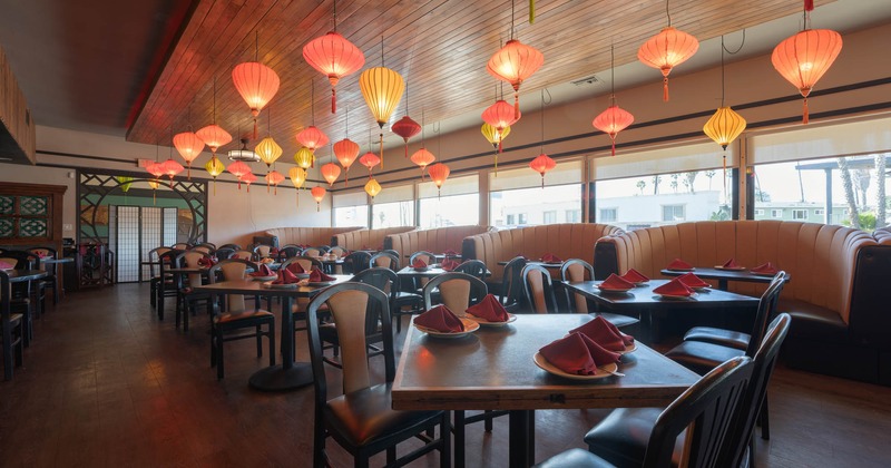 Interior, dining room with tables set for dining and silk lanterns on the ceiling